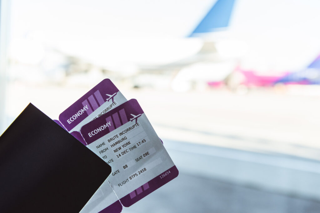 Twee vliegtickets en een reistas in een luchthaven, geboekt via vlucht-ticket.nl