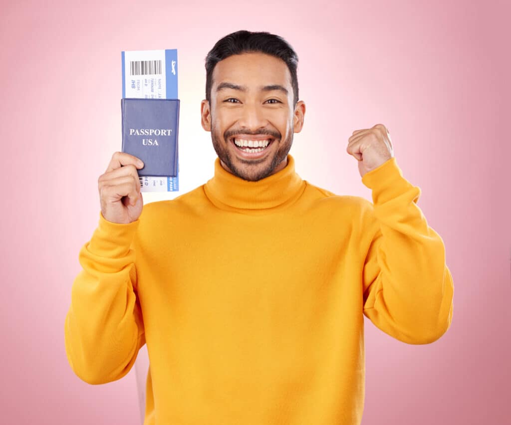 Gelukkige man in gele trui met een paspoort en vliegticket in zijn hand, symboliserend budgetvriendelijke vliegtickets bij Vlucht-Ticket.nl.