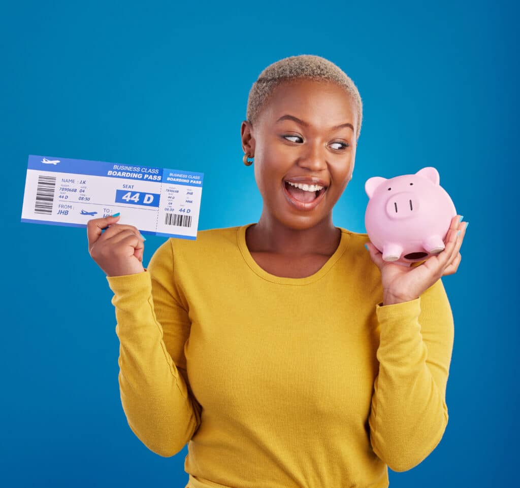 Lachende vrouw met een vliegticket in de ene hand en een spaarvarken in de andere, illustrerend goedkope vluchten via Vlucht-Ticket.nl.