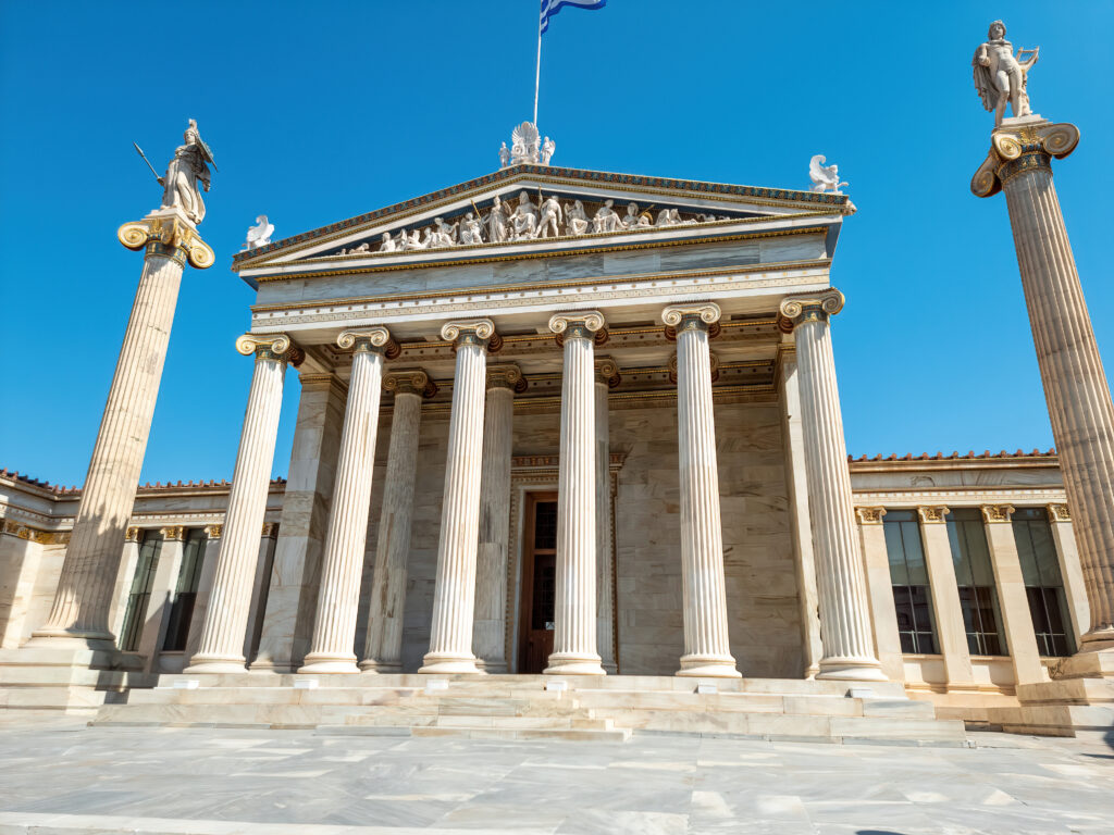 Neoklassieke gevel van het Athenaeum Eridanus Luxury Hotel in Athene, Griekenland, met iconische zuilen en blauwe lucht.