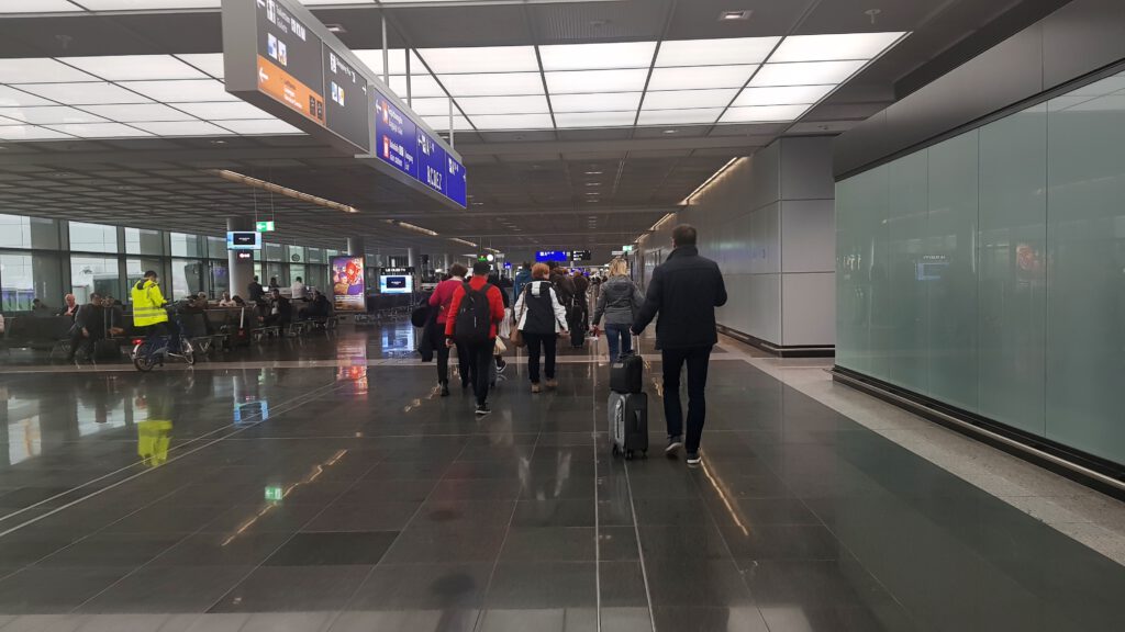 Passagiers lopen door de vertrekhal van Rotterdam The Hague Airport, klaar voor hun vlucht.