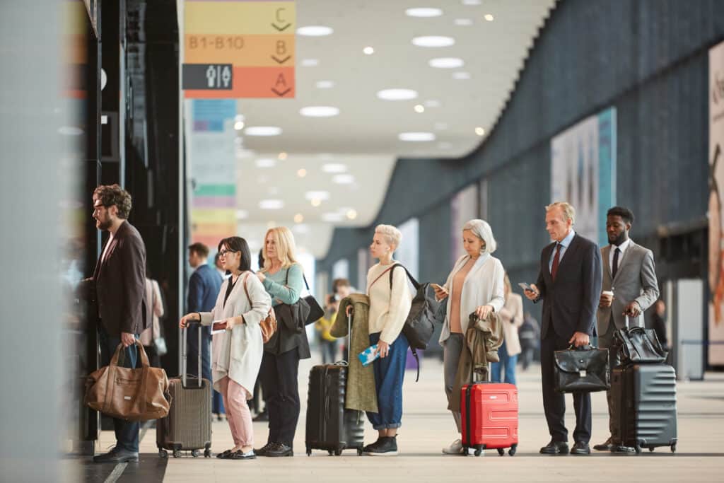 Reizigers in een wachtrij op een luchthaven, klaar om in te checken voor hun vlucht, symbolisch voor het vinden van voordelige vliegtickets deals in België via Vlucht-Ticket.nl.