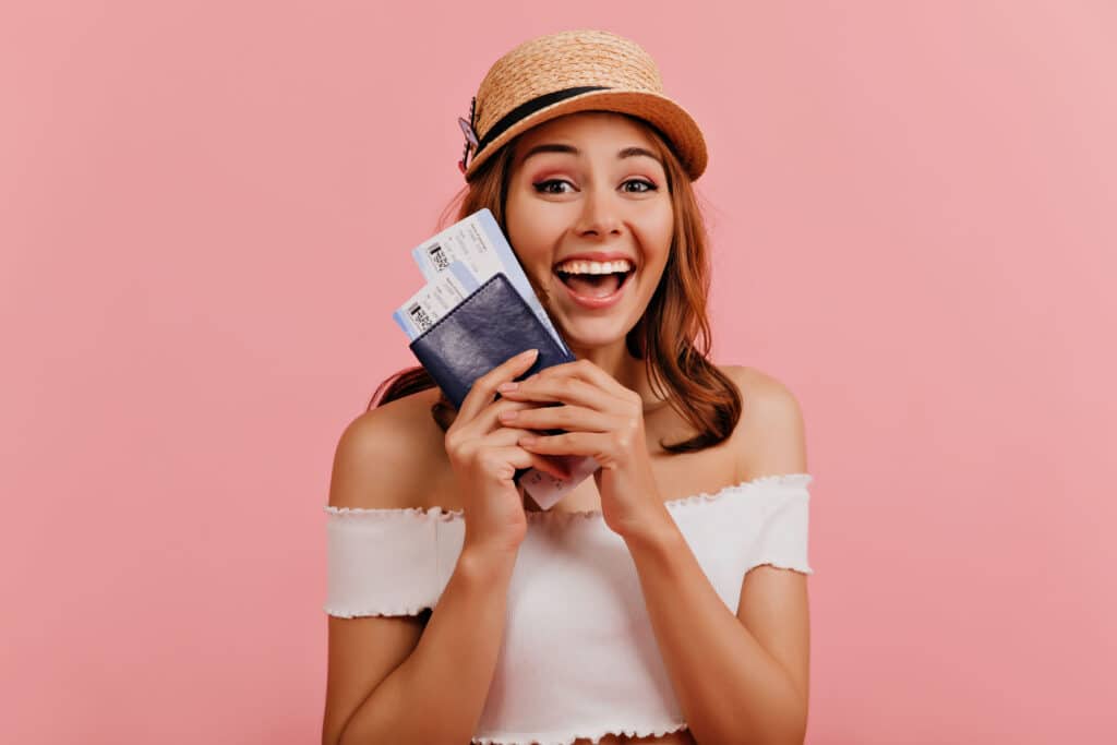 Blije reiziger met vliegtickets en paspoort in de hand, klaar om op reis te gaan – ontdek hoe je vluchtprijzen kunt vergelijken en besparen op vliegtickets bij Vlucht-Ticket.nl.