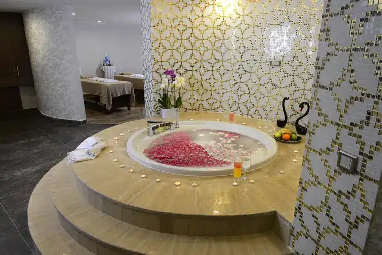 Luxe jacuzzi met bloemen en kaarsen in de spa van Wome Deluxe Hotel