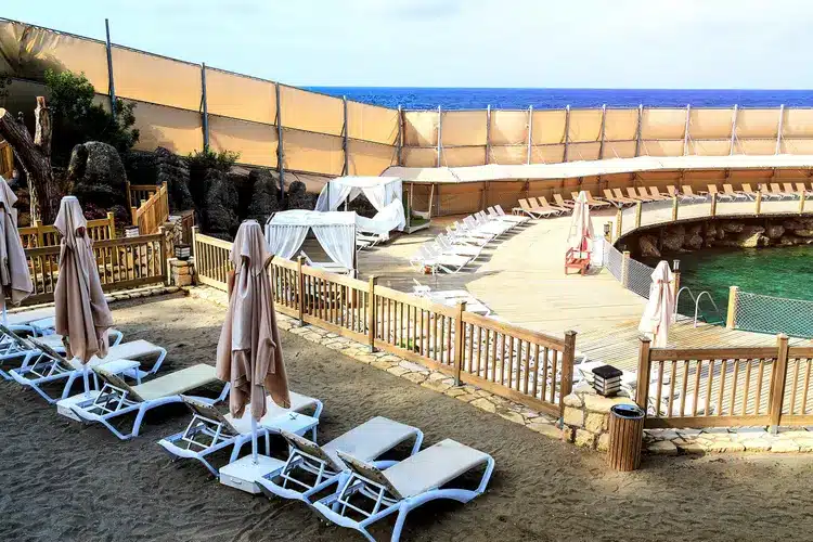 Gescheiden vrouwenstrand met luxe ligbedden en privacywanden in Wome Deluxe Hotel