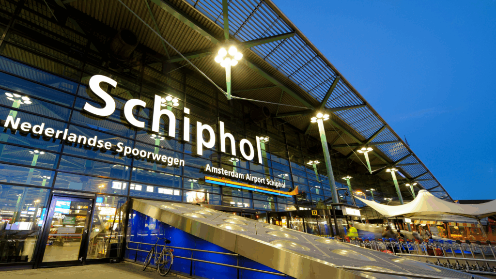 Ingang van Schiphol Airport bij avond – ideale vertrekplaats voor reizigers uit Amsterdam-West