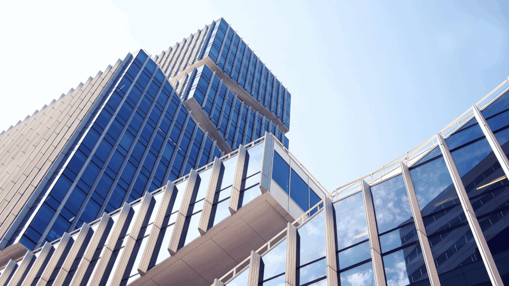 Modern zakelijk gebouw in Amsterdam-Zuid met spiegelende ramen en blauwe lucht, symbool voor reizen en internationale verbindingen