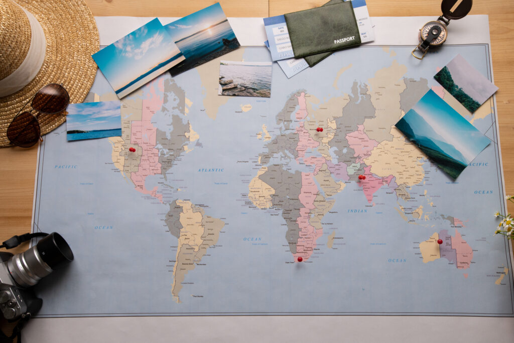 Wereld bestemmingen wereldkaart met pins, paspoort, camera en foto’s.