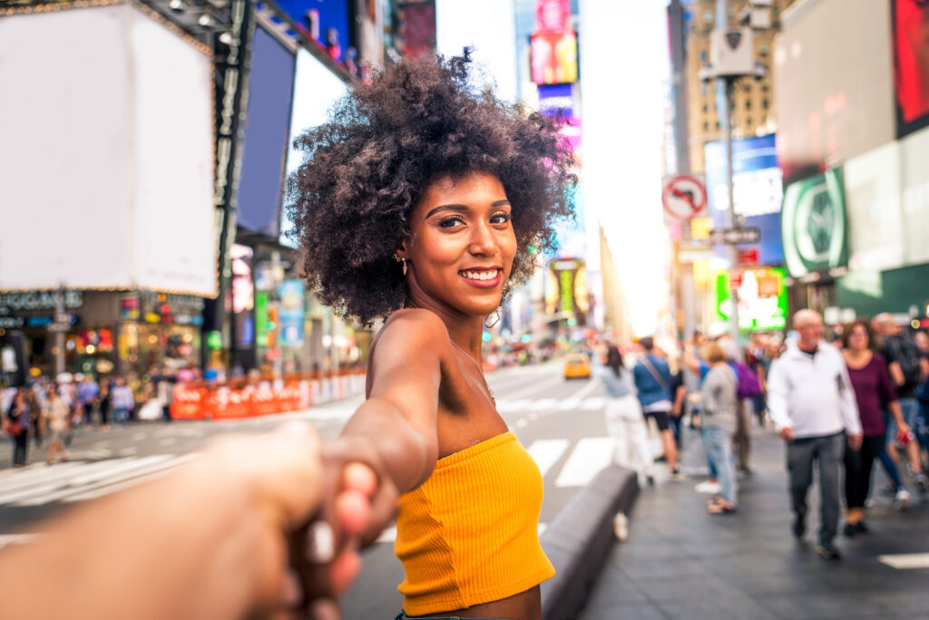 Vrouw geniet van haar bezoek aan Times Square in New York, omringd door neonreclames en levendige sfeer.
