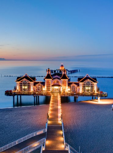 Pier met een sfeervol verlicht restaurant aan de Baltische Zee, ideaal voor romantische halal vakanties. Boek jouw verblijf via vlucht-ticket.nl / hotels.