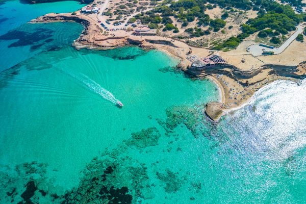 Luchtfoto van Platges de Comte, Ibiza, met turquoise wateren en een serene omgeving, perfect voor een strandvakantie.