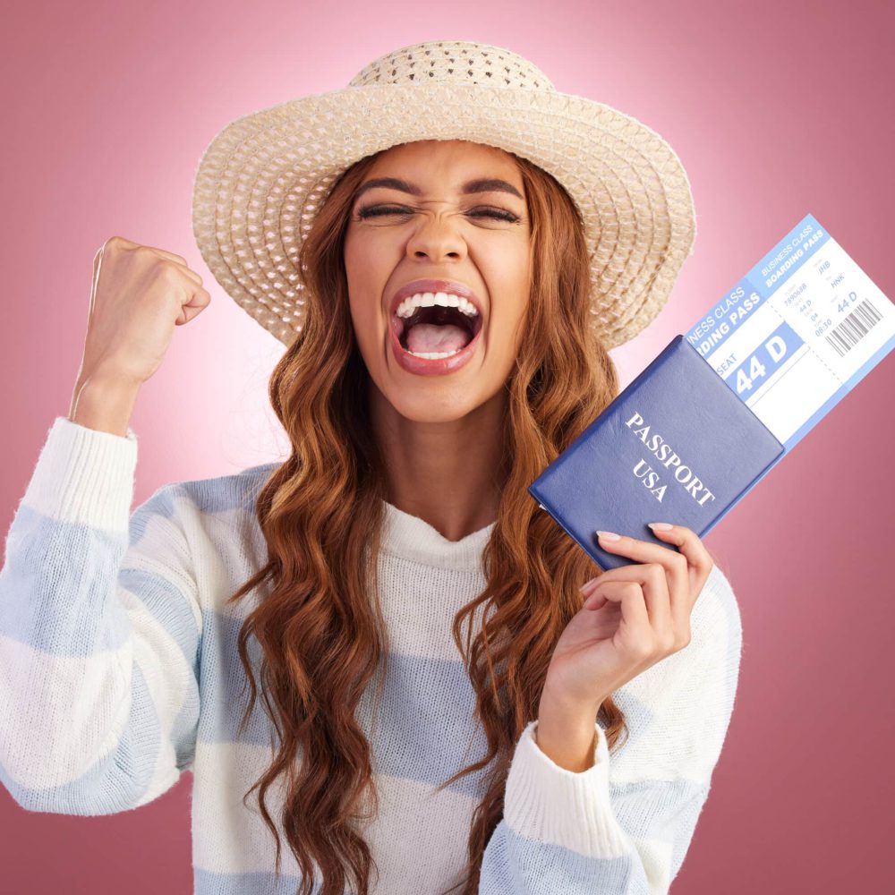 Vrolijke vrouw met een hoed die een Amerikaans paspoort en vliegticket vasthoudt, klaar om haar vlucht direct te boeken.